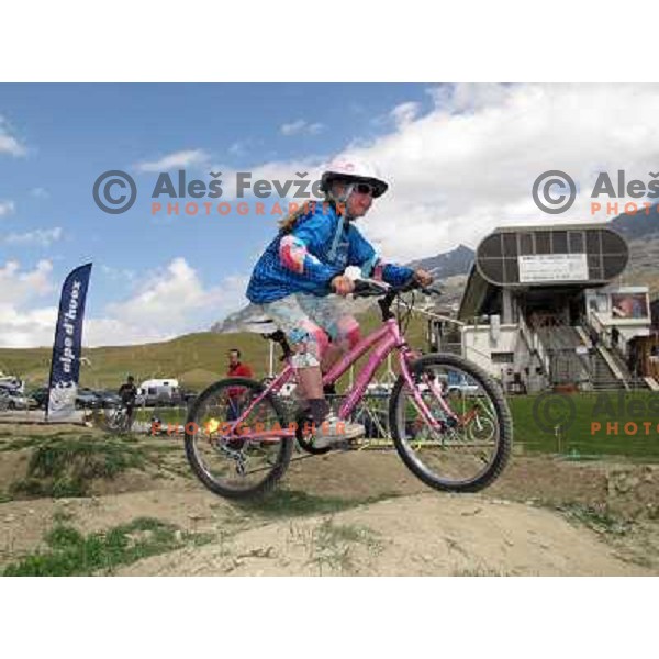 Little kids having first riding class in MTB park in Alpe d\'Huez ski resort, France on August 3, 2011 