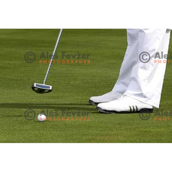 Golf shoes and putter on the green during a round of golf in Slovenia, Europe