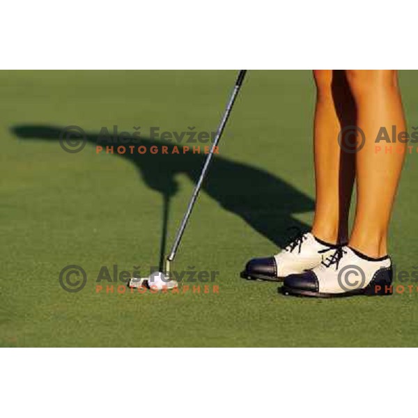 Golf shoes and putter on the green during a round of golf in Slovenia, Europe