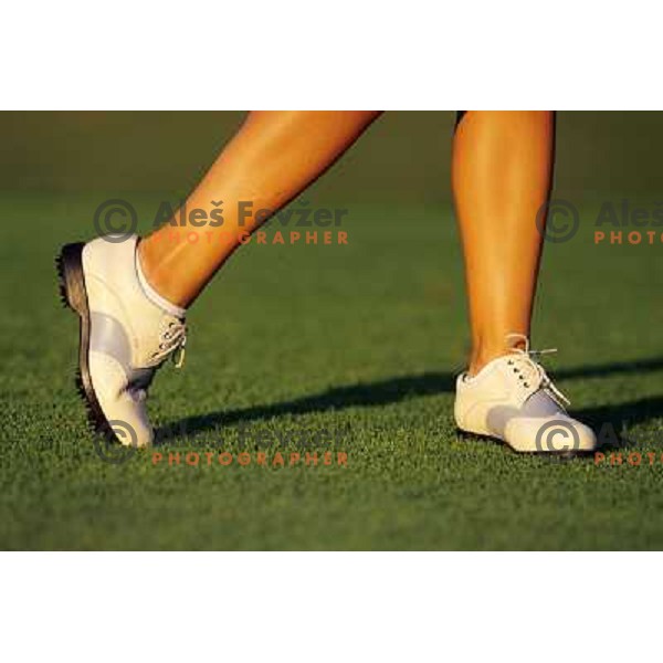 Golf shoes and putter on the green during a round of golf in Slovenia, Europe