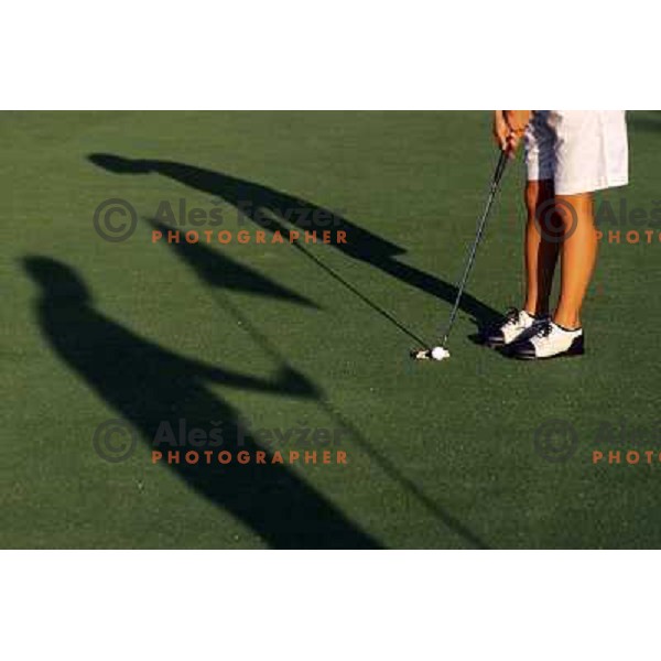 Golf shoes and putter on the green during a round of golf in Slovenia, Europe