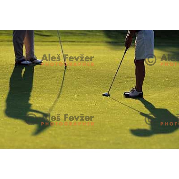 Golf shoes and putter on the green during a round of golf in Slovenia, Europe
