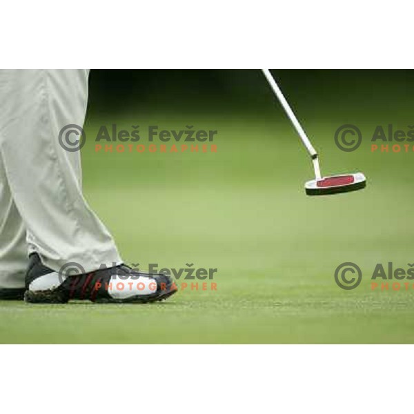 Golf shoes and putter on the green during a round of golf in Slovenia, Europe
