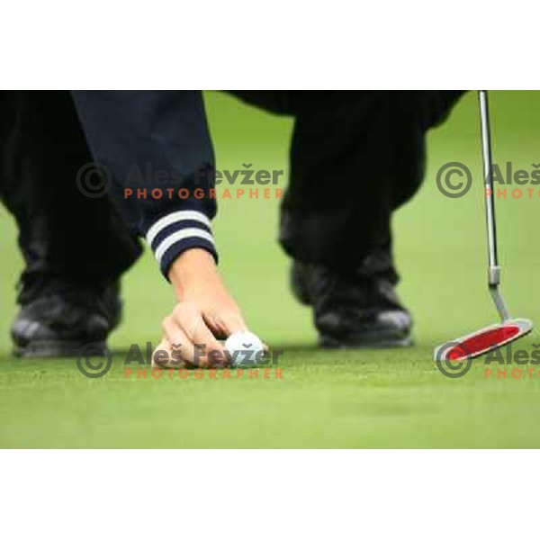 Golf shoes and putter on the green during a round of golf in Slovenia, Europe