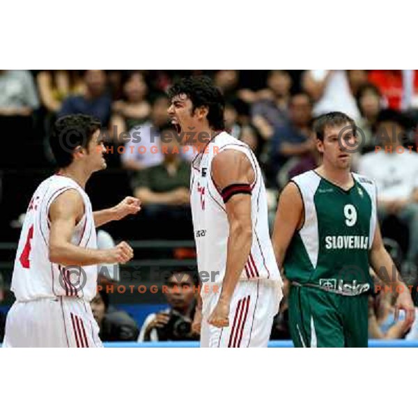Kerem Gonlum ( in the middle) celebrates scoring a basket against Slovenia