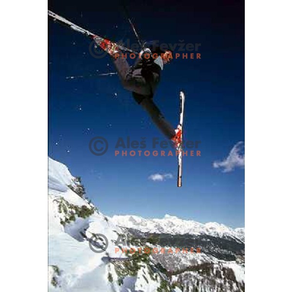Skier performing a jump at Vogel ski resort with Mt. Triglav (2864 meters) the highest peak in Slvoenia in background