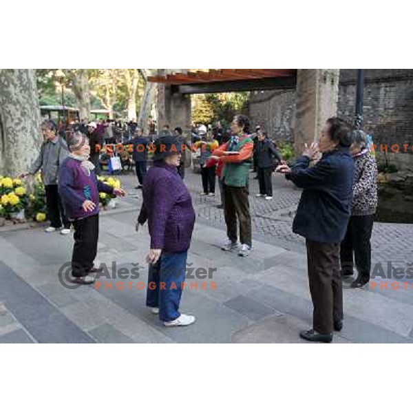 Chinese people practicing Tai Chi and gymnastics during early morning in downtown Shanghai. Tai chi is a type of internal Chinese martial art practiced for both its defense training and its health benefits. Shanghai has more than 25 million people. It is